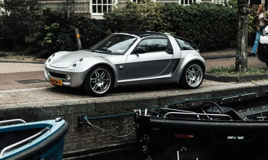 Petite voiture sans permis garée en ville, conducteur à bord et panneau de signalisation visible